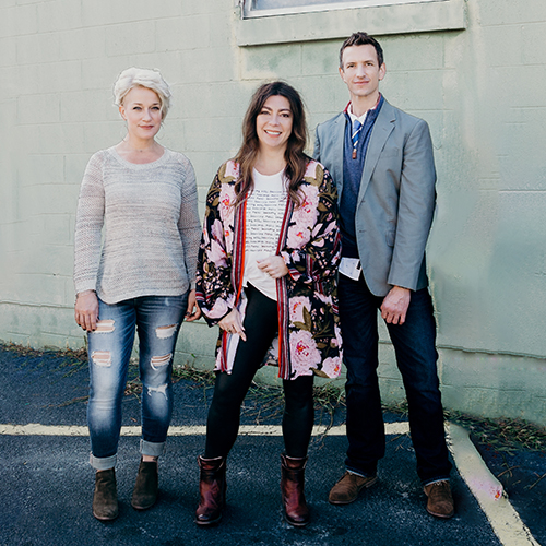 Kirsten, Sandra and Greg in front of brick wall